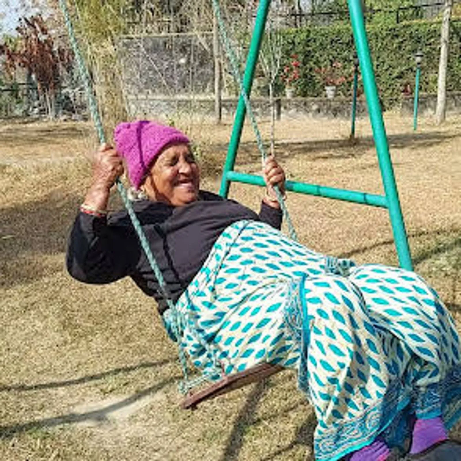 A resident laughing on the garden swing